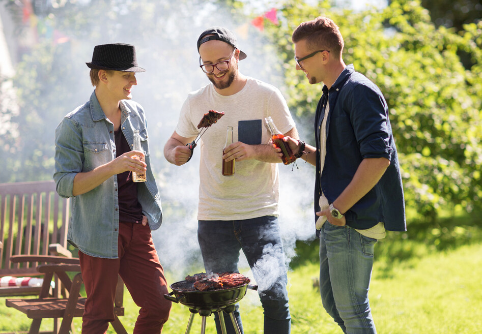 3 mænd står rundt om en grill